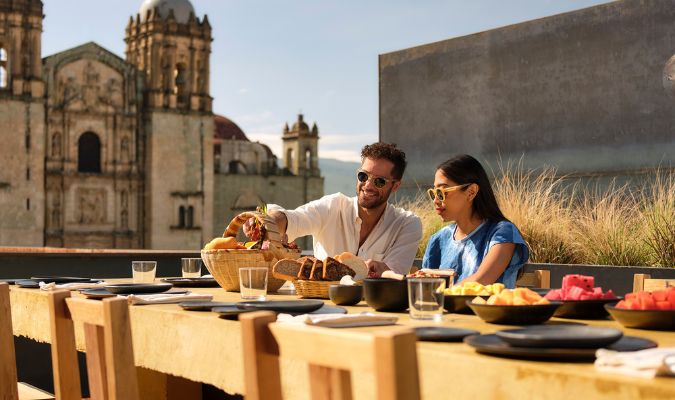 otro oaxaca couple eating in communal table