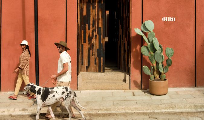 otro oaxaca couple outside entrance with dog